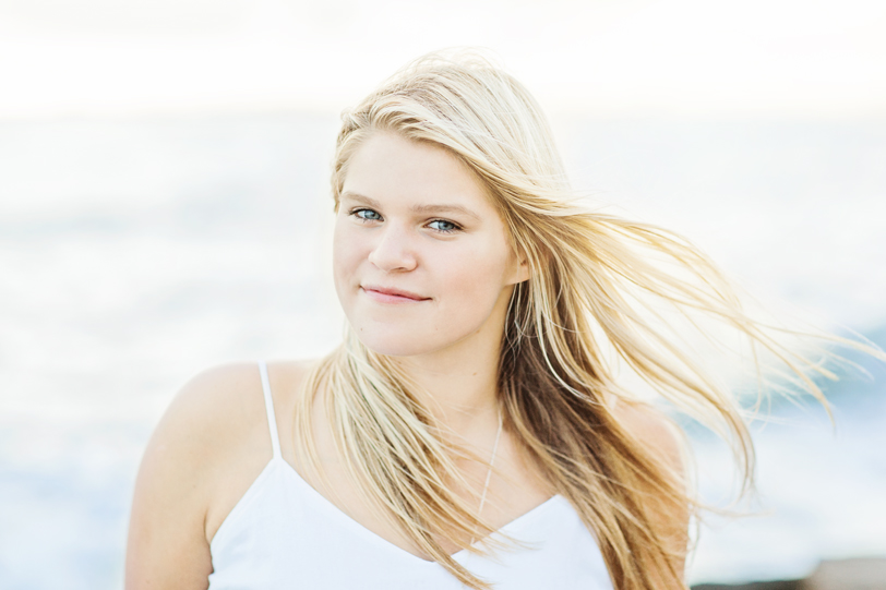 Senior girl during portrait session on beach with wind in her hair