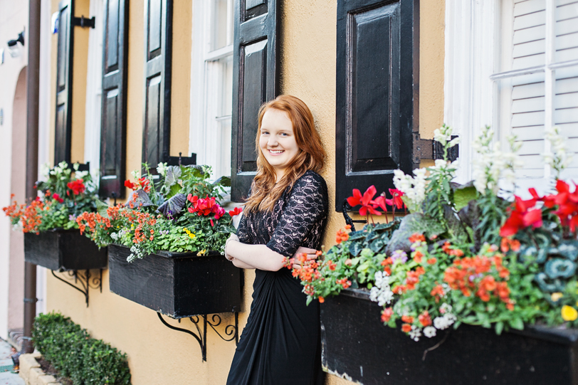 High School Senior by yellow house with black shutters on Rainbow Row in Charleston, SC | Kaitlin Scott Photography