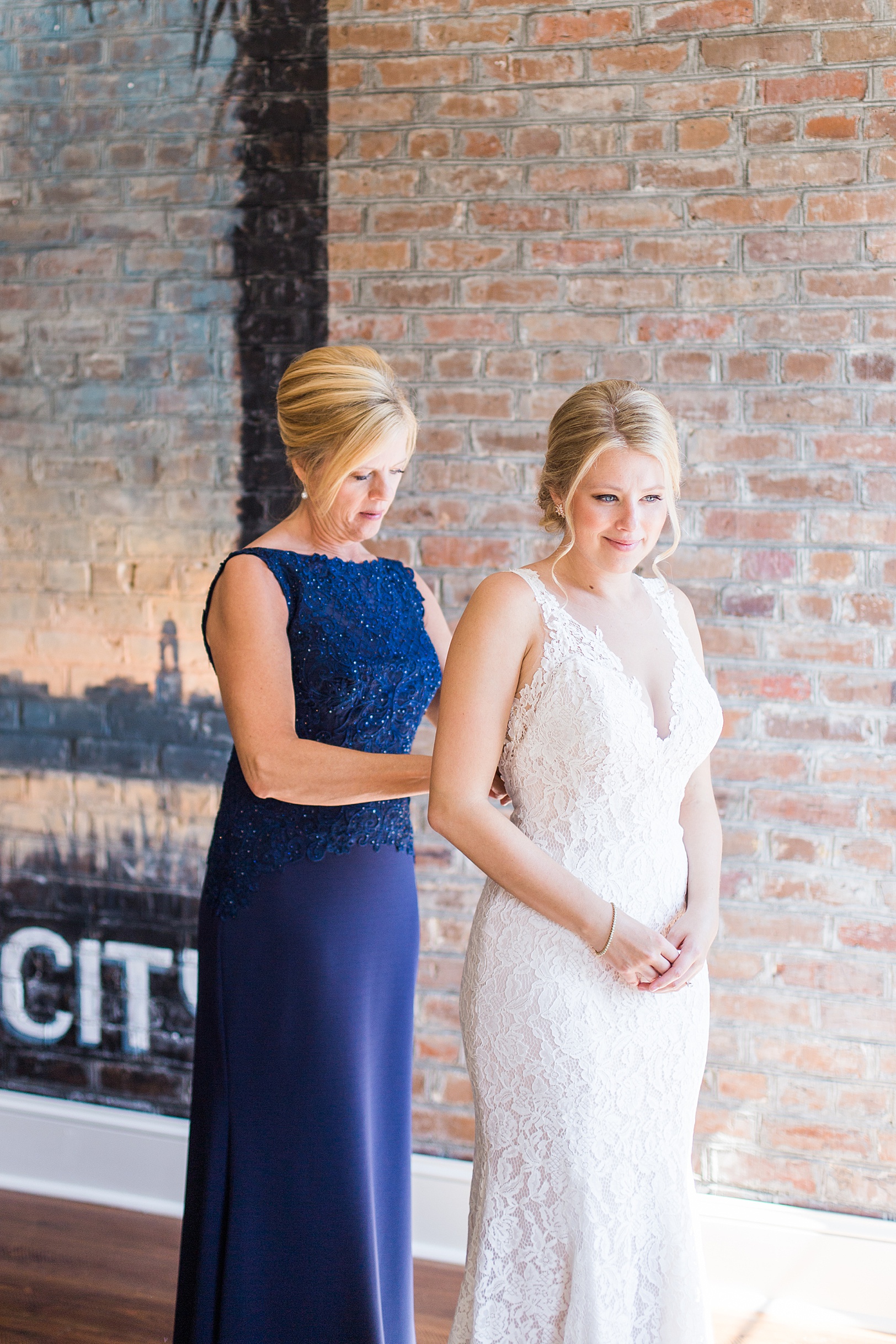 Mother of Bride helping Daughter get into Wedding Dress