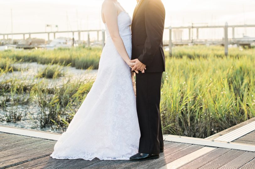 Bride and Groom holding hands with Charleston sunset at marina | Kaitlin Scott Photography