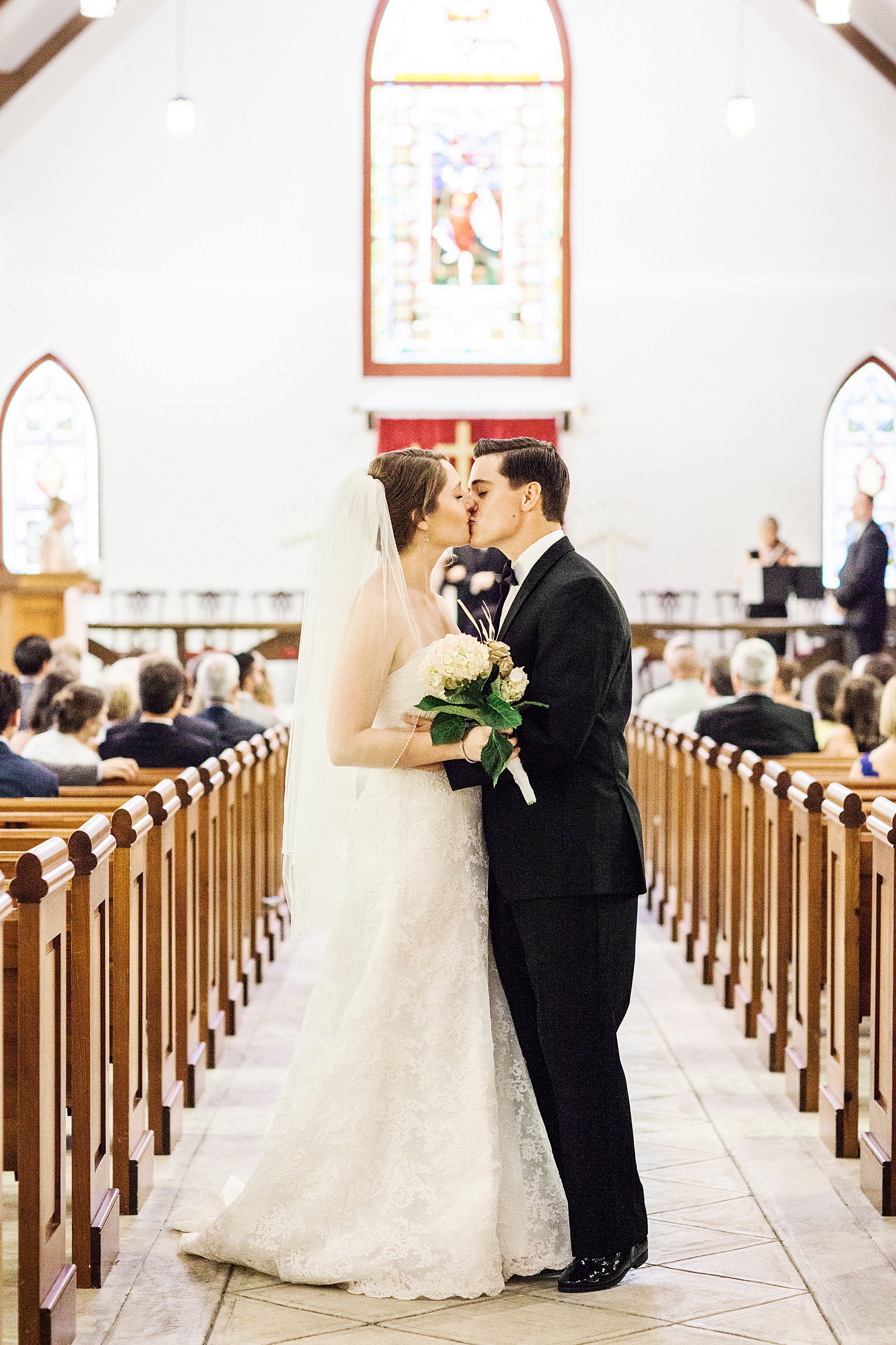 Bride and Groom Kiss on their way down aisle at St. Luke's Chapel | Kaitlin Scott Photography