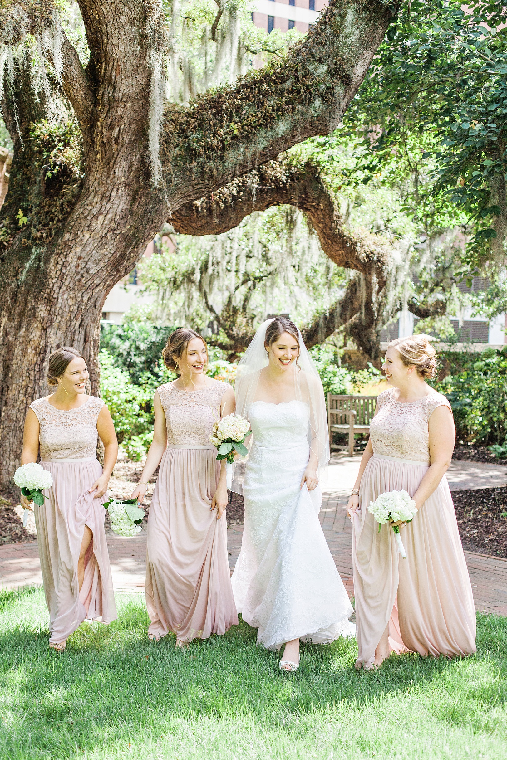 Bride walking with her pink-dressed bridesmaids at St. Luke's Chapel | Kaitlin Scott Photography