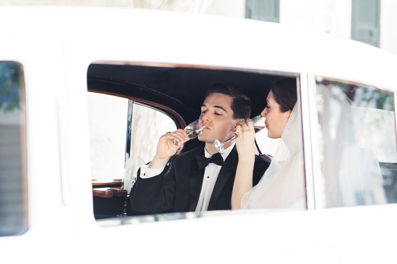 Bride and Groom celebrating with champagne in limo | Kaitlin Scott Photography