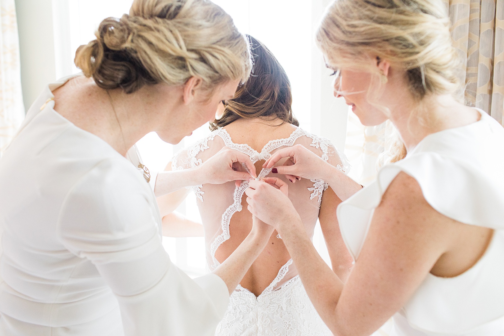 Bride's Sisters buttoning up her wedding dress | Kaitlin Scott Photography