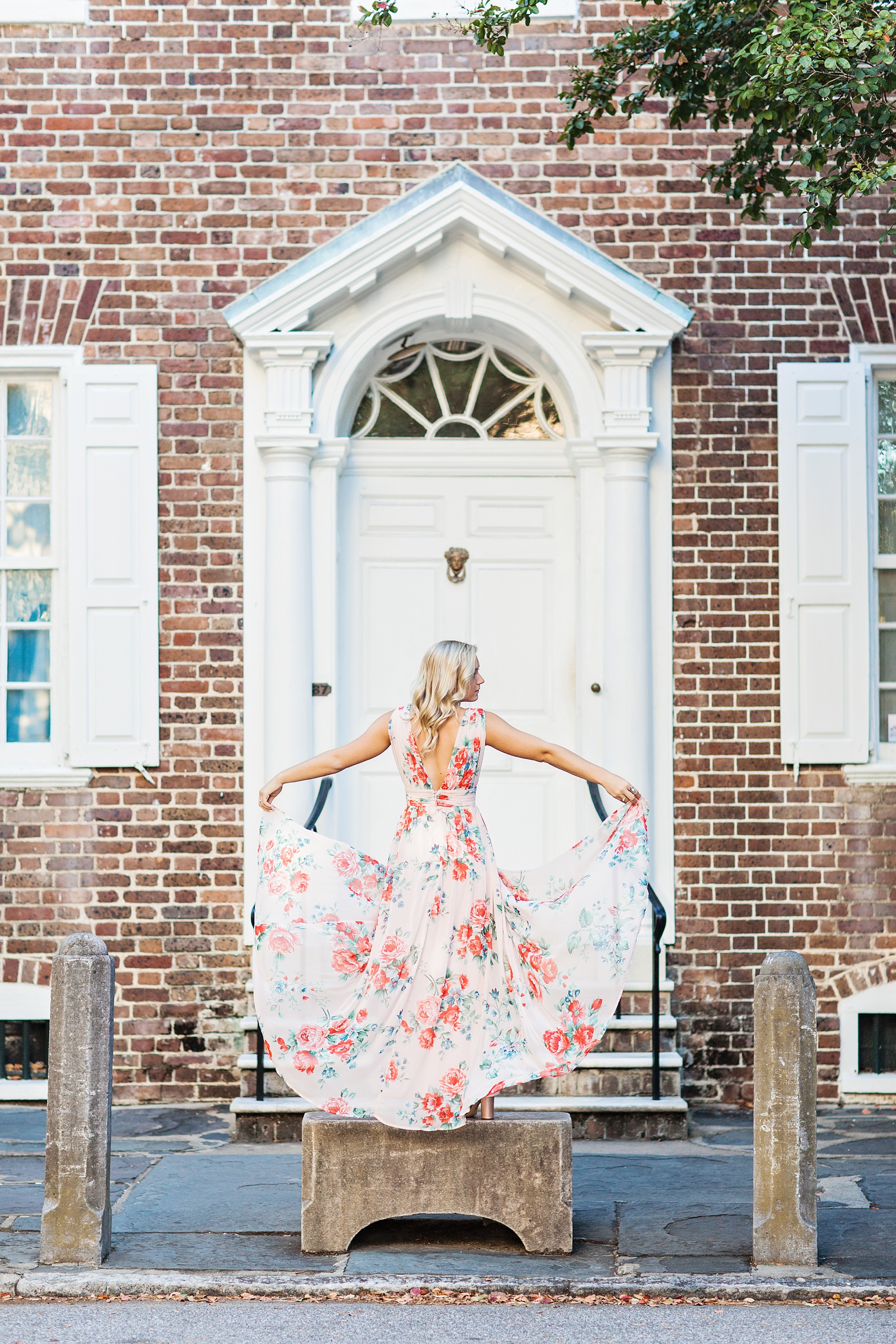 Historic Downtown Charleston Senior Session by brick home with floral dress | Kaitlin Scott Photography