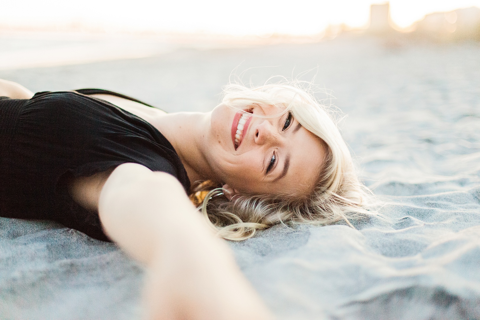 Laughing Senior playing in the sand at Folly Beach | Charleston's Kaitlin Scott Photography