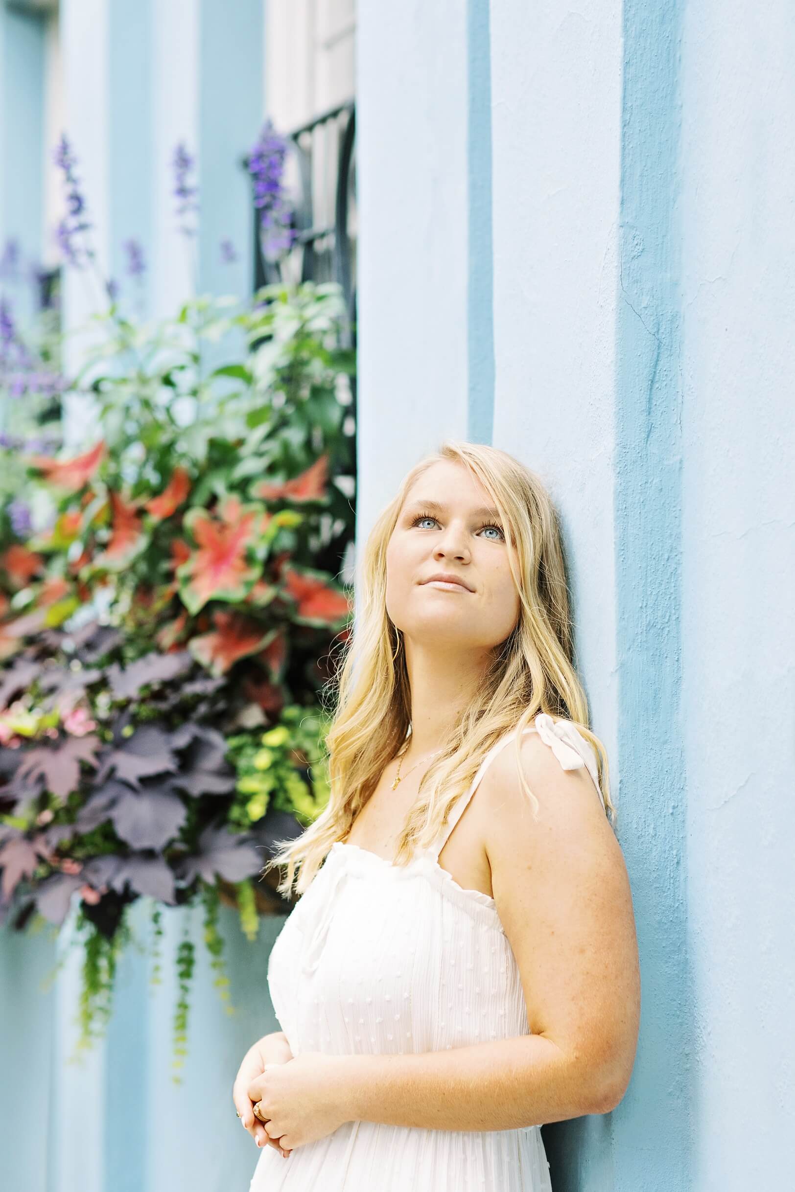 Girl in white dress with blue eyes on Charleston's Rainbow Row | Kaitlin Scott Photography