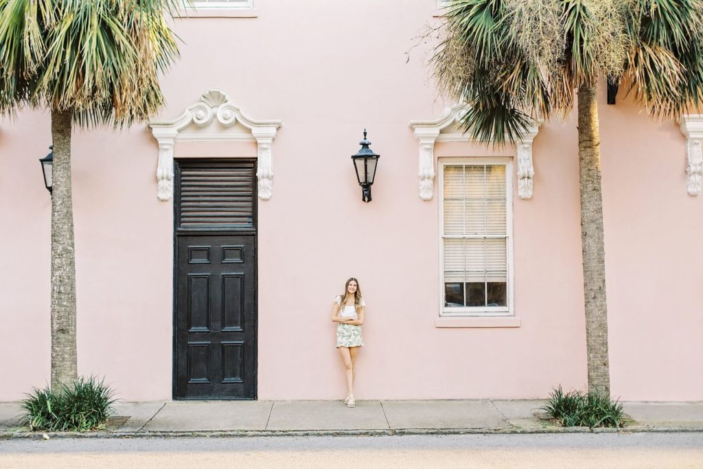 Girl standing by pink Mills House in Charleston