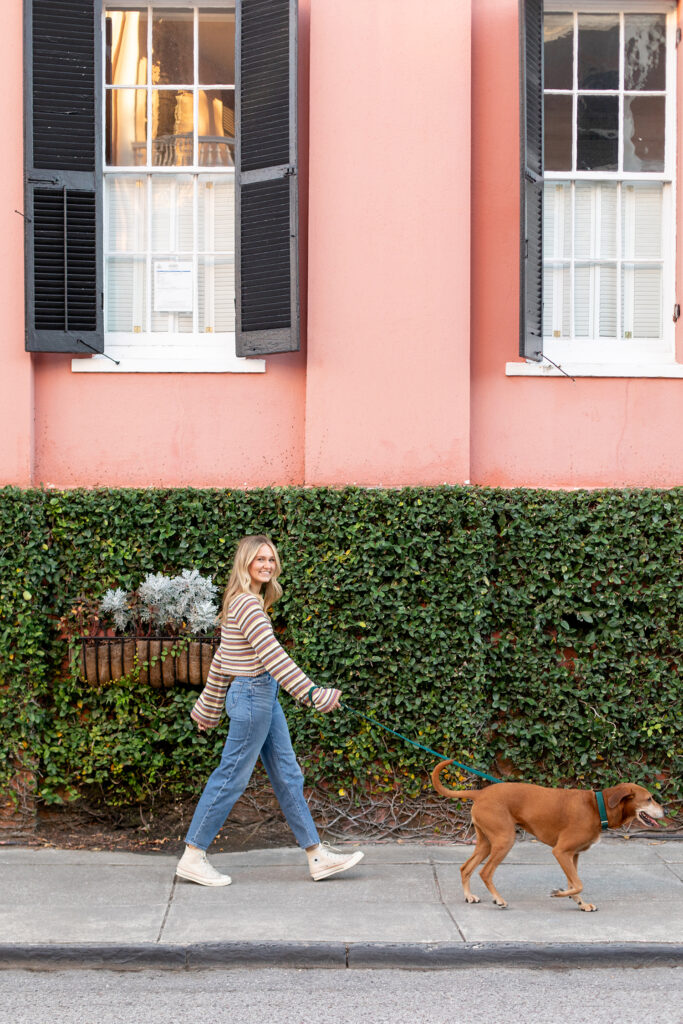 Girl walking her dog by pink house South of Broad