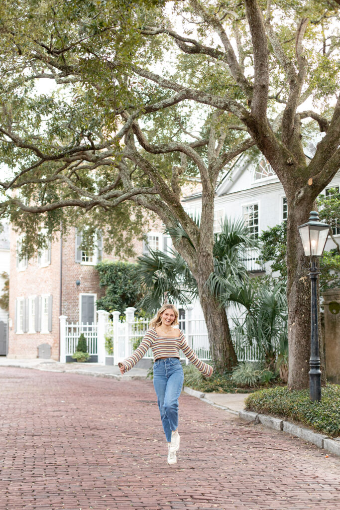 Girl jumping under trees in downtown Charleston